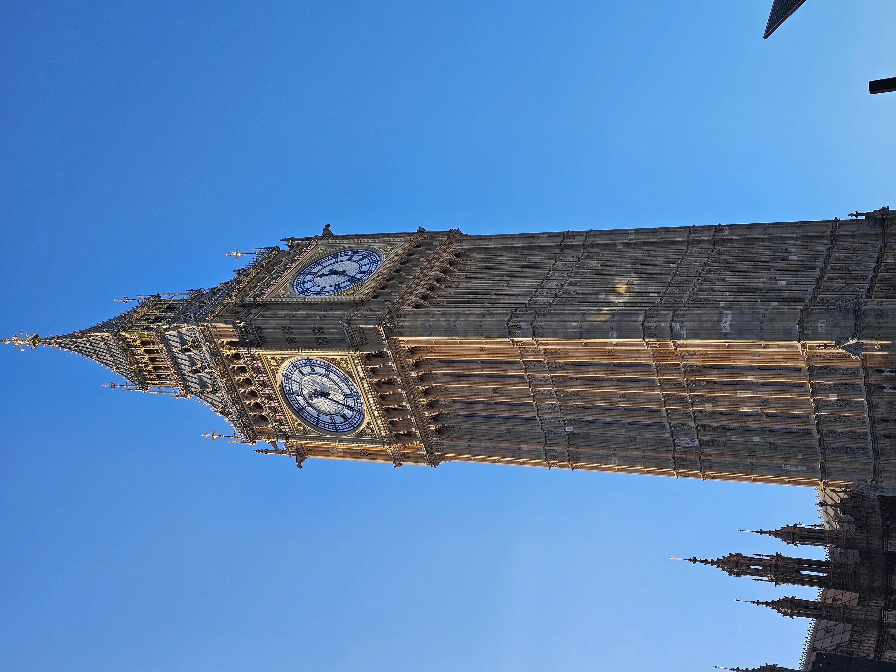 The Elizabeth Tower and Big Ben against a clear blue London sky