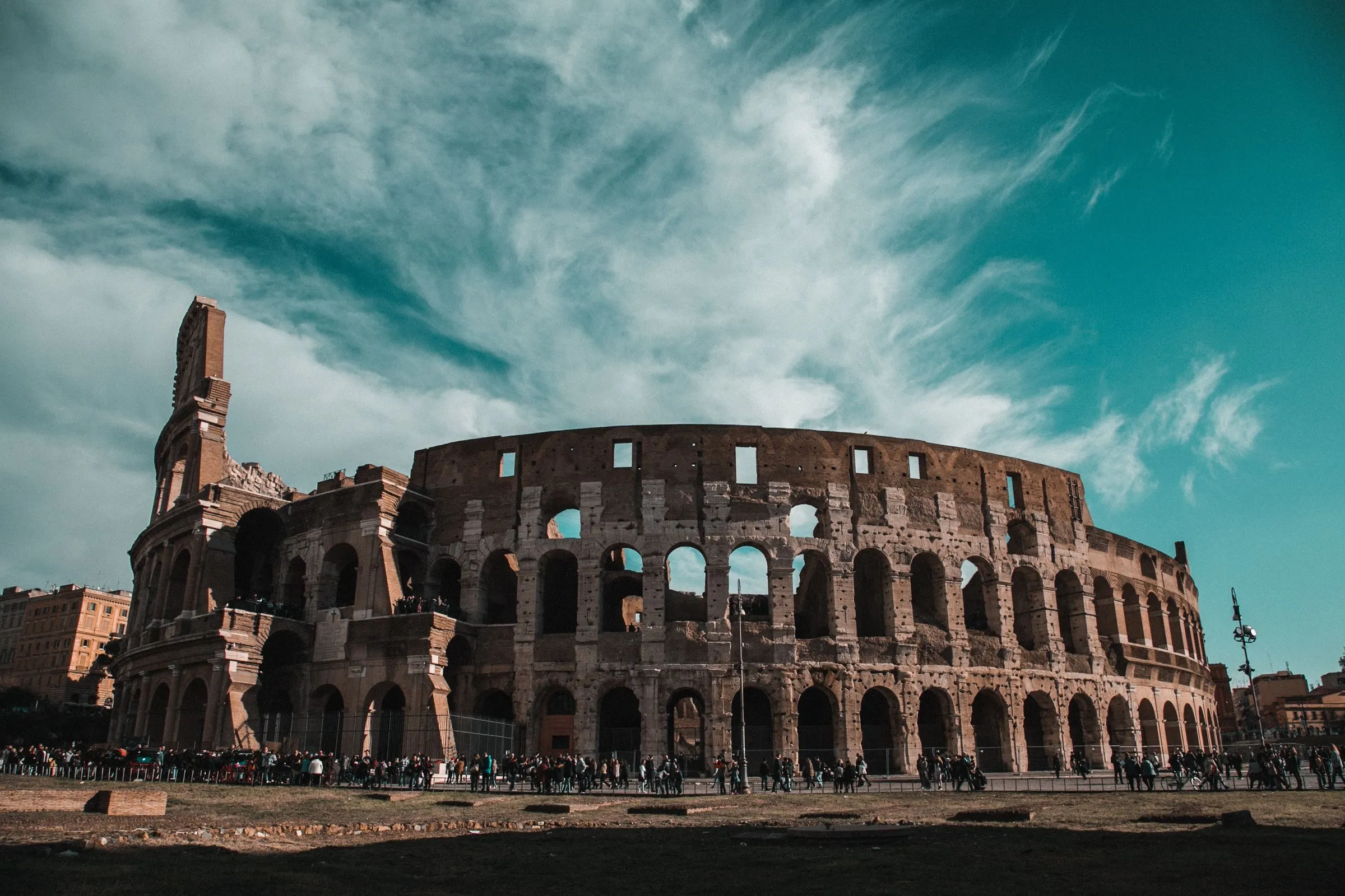 The arches of the Colosseum beneath a dramatic Roman sky